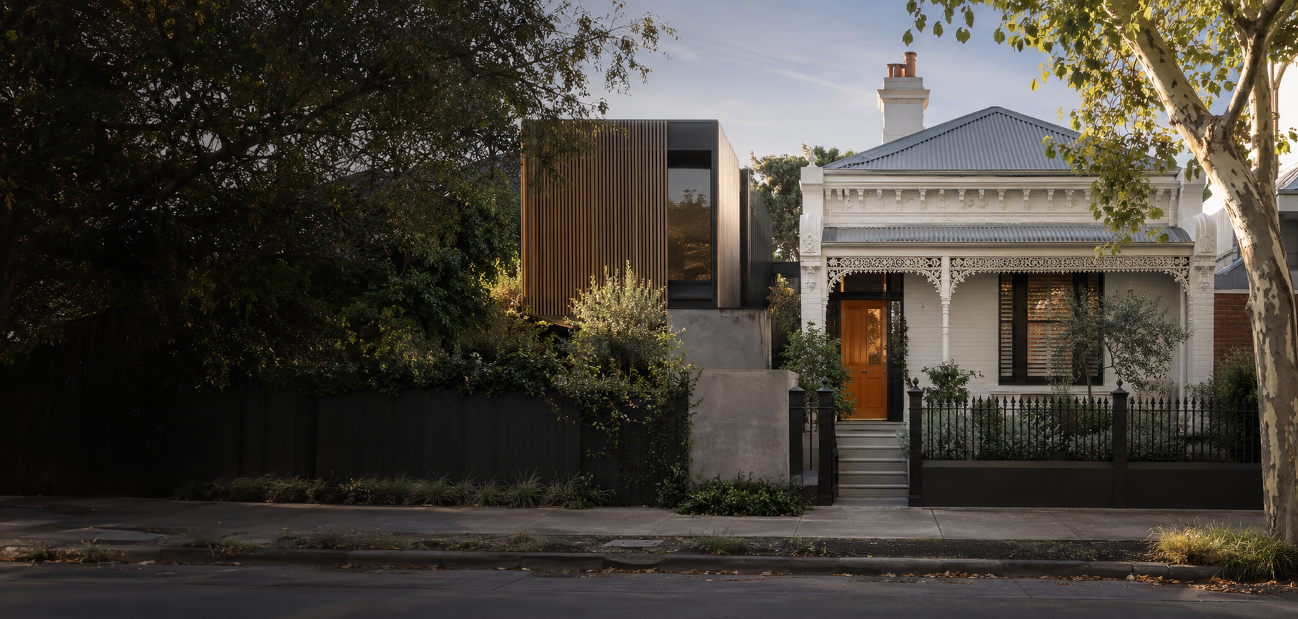 A restored Melbourne heritage home with a contemporary timber-clad rear extension at dusk